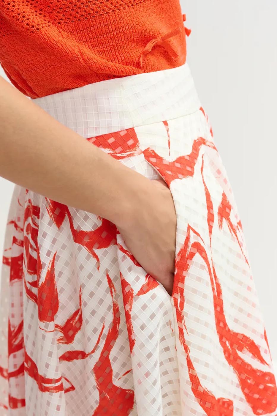 Jupe mi-longue plissée blanc cassé et rouge à fleurs